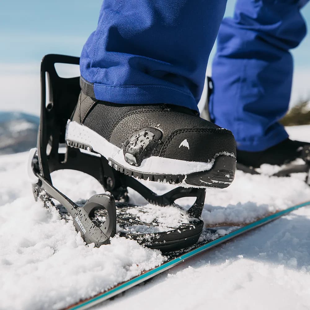 Nahaufnahme eines Snowboardboots in einer Burton-Step-On-Bindung im Neuschnee