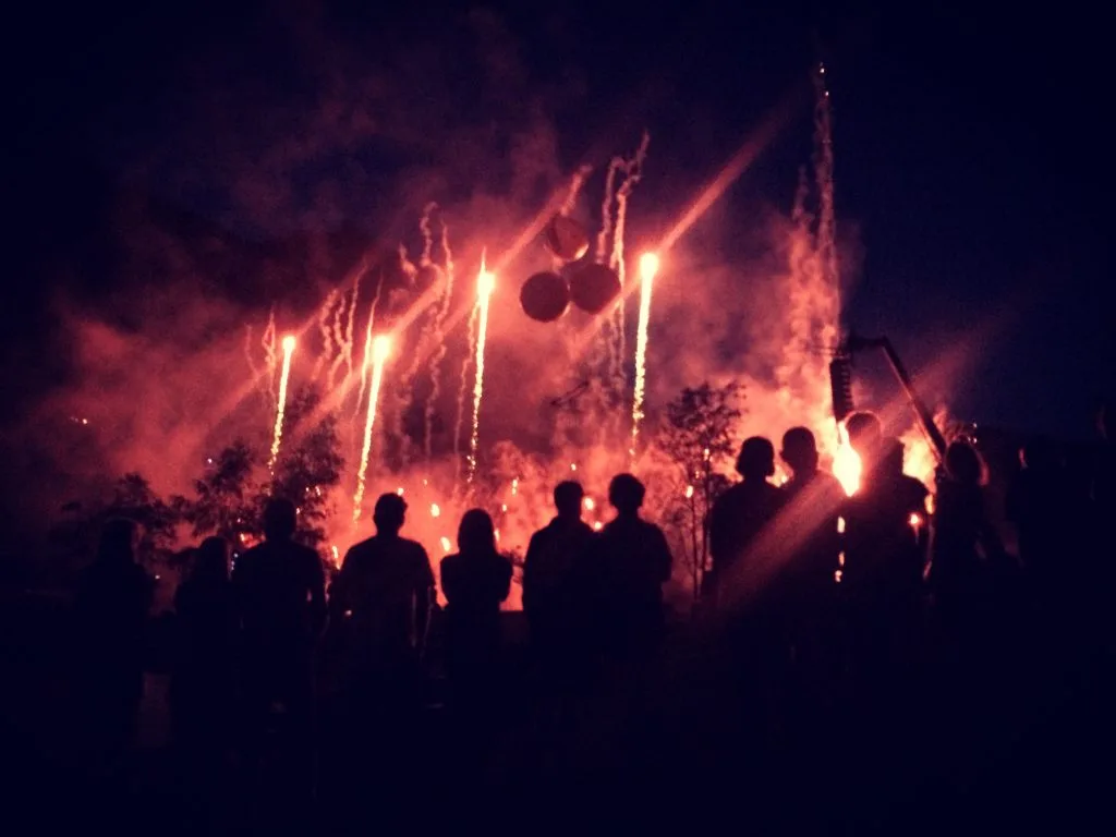 Silhouetten einer Menschenmenge, die ein Feuerwerk am Nachthimmel beobachtet