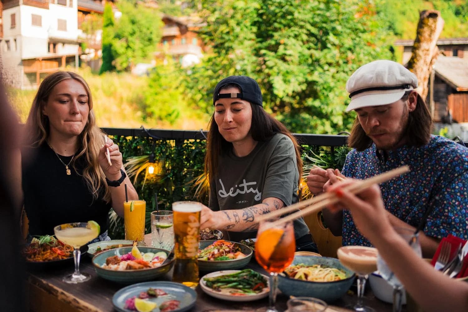 Freunde essen zusammen an einem Tisch voller asiatischer Gerichte zum Teilen