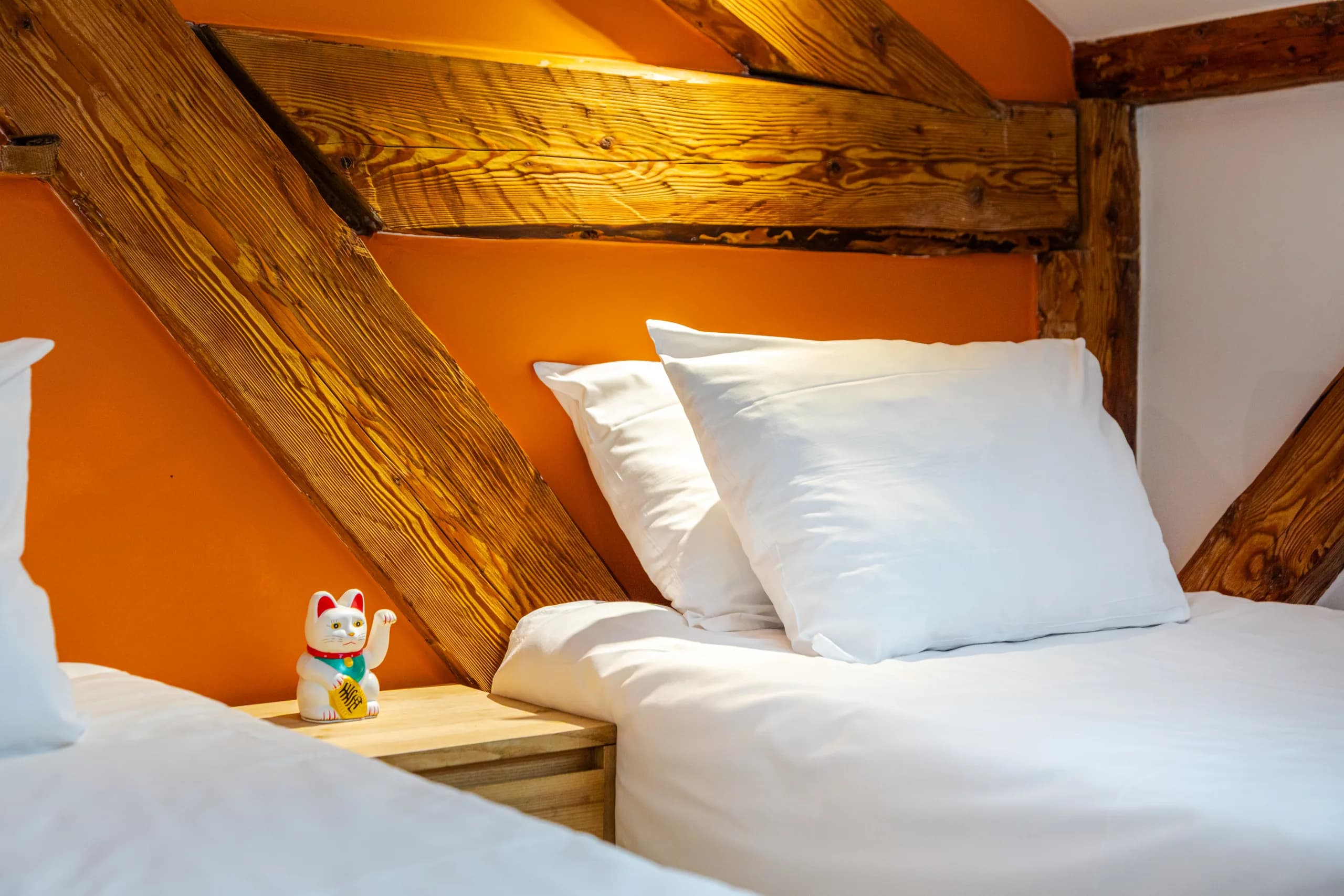 Bett in einem Zimmer im Hideout unter freiliegenden Holzbalken
