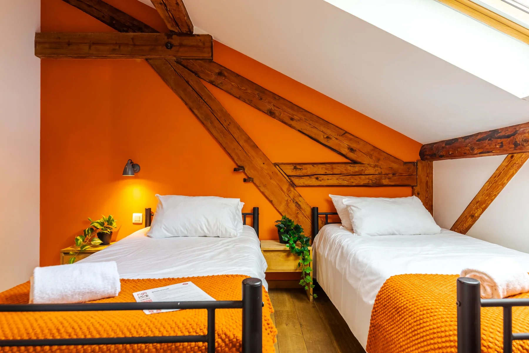 Standard-Zweibettzimmer mit orangefarbenen Decken und Oberlicht